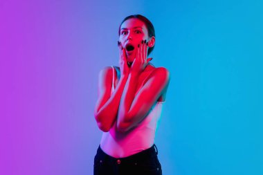 Beyaz kadın portresi, neon ışıklarıyla mavi-mor renkli gradyan stüdyo arka planında.