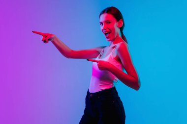 Beyaz kadın portresi, neon ışıklarıyla mavi-mor renkli gradyan stüdyo arka planında.