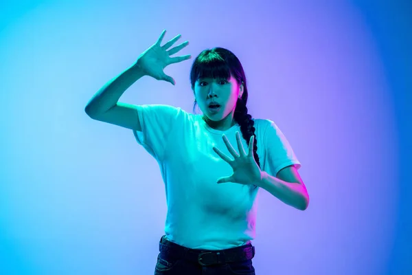 Jeune asiatique womans portrait sur dégradé bleu-violet studio fond en néon lumière — Photo