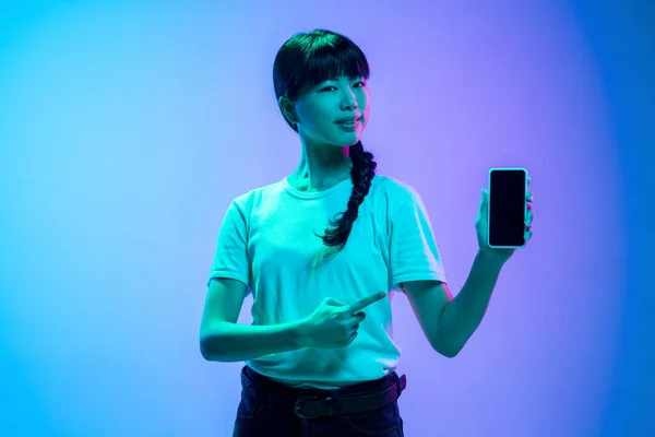 Jeune asiatique womans portrait sur dégradé bleu-violet studio fond en néon lumière — Photo