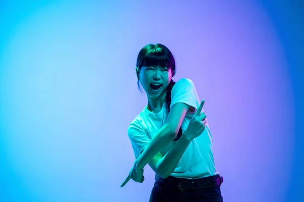 Mladé asijské ženy portrét na gradient blue-purple studio pozadí v neonovém světle — Stock fotografie