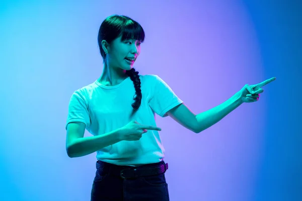 Jeune asiatique womans portrait sur dégradé bleu-violet studio fond en néon lumière — Photo