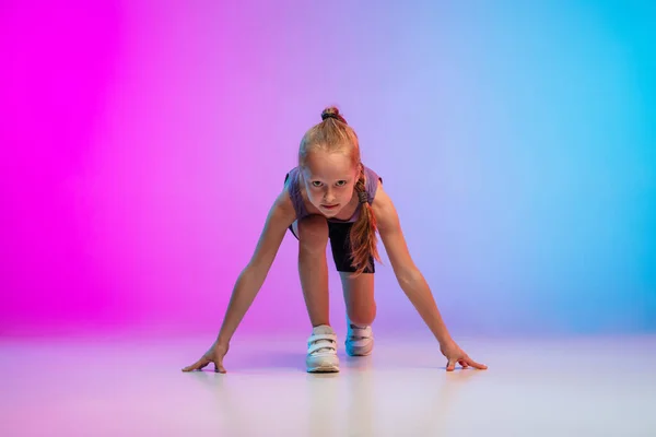 Adolescente courir, jogging contre dégradé rose-bleu néon studio fond en mouvement — Photo