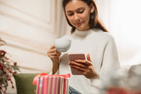 Woman writing message, greetings for New Year and Christmas 2021 for friends or family with her cellphone