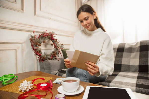 Woman opening, recieving greeting card for New Year and Christmas 2021 from friends or family