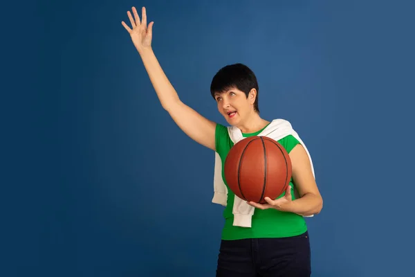 Oudere vrouw geïsoleerd op blauwe achtergrond. Technisch en vrolijk ouderenlevensstijl concept — Stockfoto