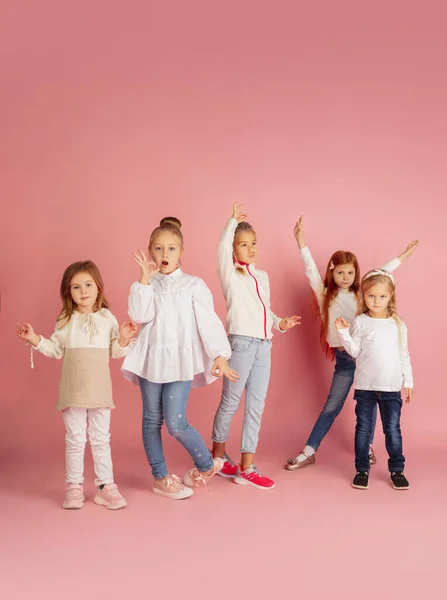 Portret van kleine blanke kinderen met heldere emoties geïsoleerd op roze studio achtergrond — Stockfoto