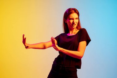 Beyaz kadın portresi, mavi-sarı gradyan stüdyo arka planında neon ışığı altında.