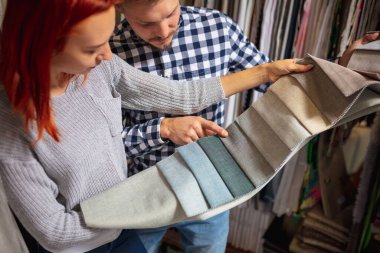 Ev dekorasyonu dükkanında, dükkanda tekstil seçen bir çift. Karantina sırasında ev iç tasarımının yapımı