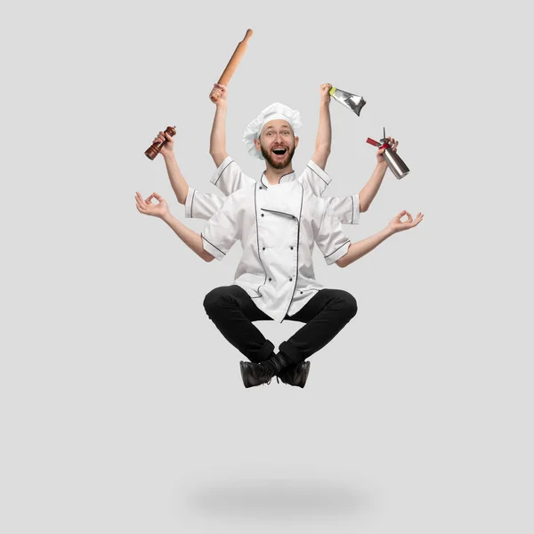 Kookplaat, chef-kok, bakker in uniform multitask zoals shiva geïsoleerd op grijze studio achtergrond — Stockfoto