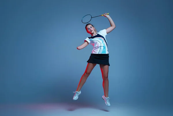 Vackra handikapp kvinna tränar i badminton isolerad på blå bakgrund i neon ljus — Stockfoto