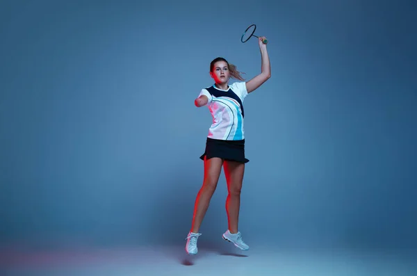在霓虹灯下与蓝色背景隔离的羽毛球练习的漂亮残疾女子 — 图库照片
