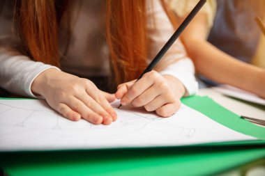 Evin yaratıcılığı için iki küçük kızın ellerini birbirine yakın tut. Çocuklar oyunlar ya da yeni yıl kutlamaları için el yapımı oyuncaklar yapıyorlar.