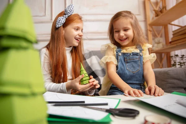 Due bambini piccoli, ragazze insieme in creatività della casa. I bambini felici fanno giocattoli fatti a mano per i giochi o la celebrazione di Capodanno — Foto Stock