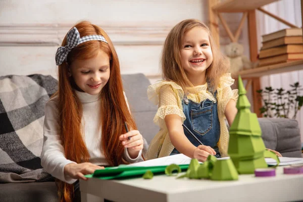 Dos niños pequeños, niñas juntas en la creatividad de la casa. Niños felices hacen juguetes hechos a mano para juegos o celebración de Año Nuevo — Foto de Stock