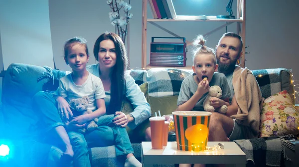 Mutlu aile projektörü, TV, akşam evde patlamış mısırlı filmler. Anne, baba ve çocuklar birlikte vakit geçiriyorlar.. — Stok fotoğraf