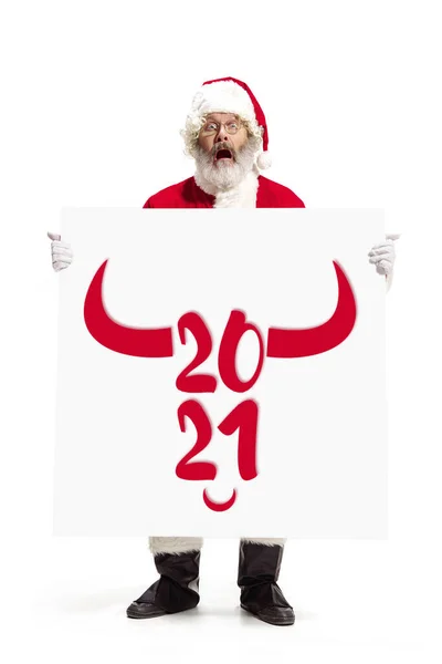 Stijlvolle kerstman in traditioneel kostuum met 2021 grote banner in handen op witte studio achtergrond — Stockfoto