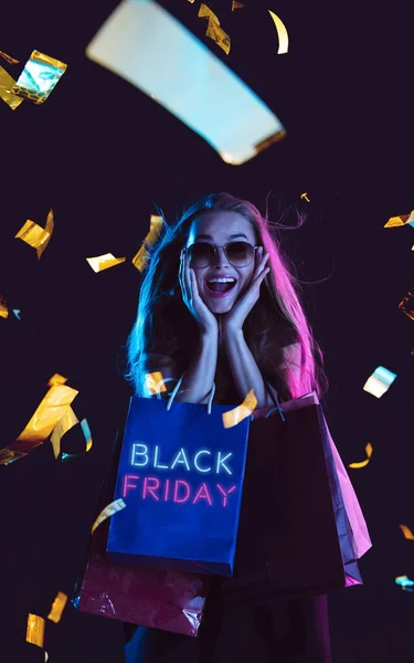 Beautiful woman inviting for shopping in black friday, sales concept. Vertical flyer, neoned style, dark background — Stock Photo, Image