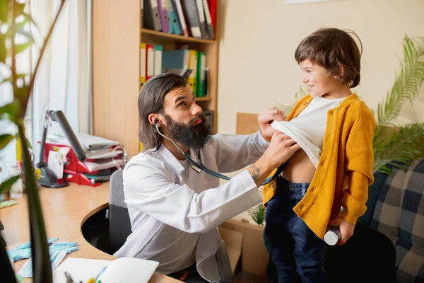 Kinderarts die een kind onderzoekt in een comfortabel medisch kantoor — Stockfoto