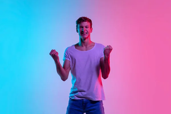Νεαρός καυκάσιος άνδρας πορτρέτο σε κλίση μπλε-ροζ φόντο στούντιο σε νέον φως — Φωτογραφία Αρχείου