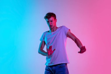 Neon ışıklarıyla mavi-pembe stüdyo arka planında beyaz adam portresi