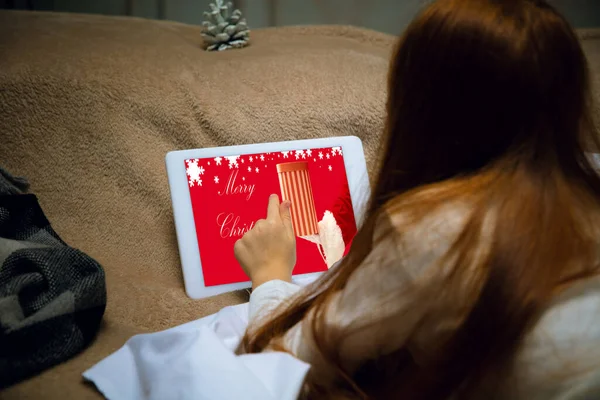 Happy caucasian little girl during video call or messaging with Santa using laptop and home devices, looks delighted and happy — Stock Photo, Image