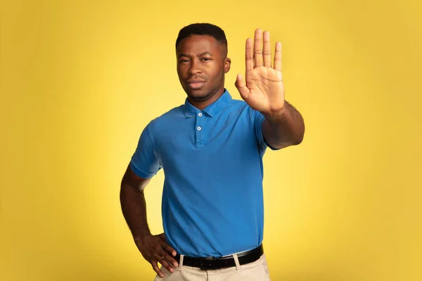 Jeunes hommes afro-américains portrait isolé sur fond de studio jaune, expression faciale. Beau portrait masculin demi-longueur avec copyspace. — Photo