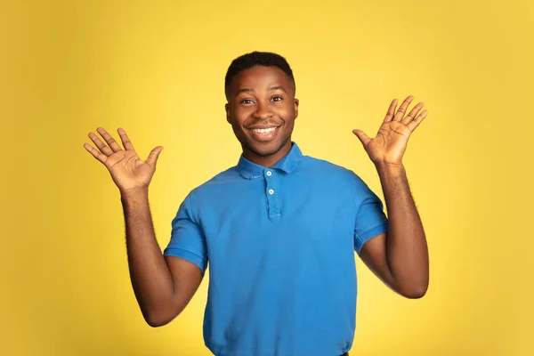 Ritratto di giovane uomo afro-americano isolato su sfondo giallo studio, espressione facciale. Bellissimo ritratto maschile a mezza lunghezza con copyspace. — Foto Stock