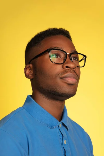 Retrato de homem jovem afro-americano isolado em fundo de estúdio amarelo, expressão facial. Bonito macho meia-comprimento retrato com copyspace. — Fotografia de Stock