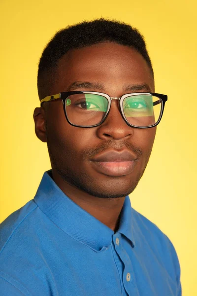 Young african-american mans portrait isolated on yellow studio background, facial expression. Beautiful male half-lenght portrait with copyspace. — Stock Photo, Image