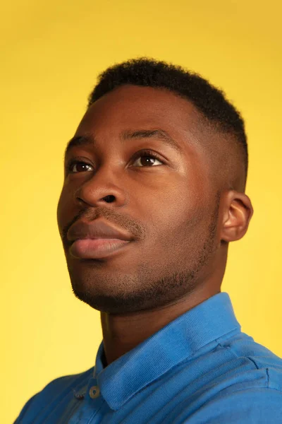 Retrato de homem jovem afro-americano isolado em fundo de estúdio amarelo, expressão facial. Bonito macho meia-comprimento retrato com copyspace. — Fotografia de Stock