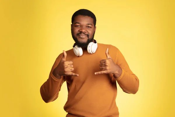 Retrato de homem jovem afro-americano isolado em fundo de estúdio amarelo, expressão facial. Bonito macho meia-comprimento retrato com copyspace. — Fotografia de Stock