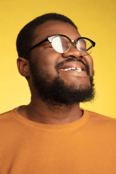 Młody afrykańsko-amerykański portret mężczyzny odizolowany na żółtym tle studia, wyraz twarzy. Piękny męski portret półdługości z przestrzenią do kopiowania. — Zdjęcie stockowe