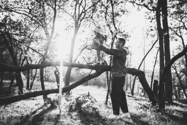 Mutlu baba ve küçük tatlı kız sonbahar güneşli bir günde orman yolunda yürüyorlar.