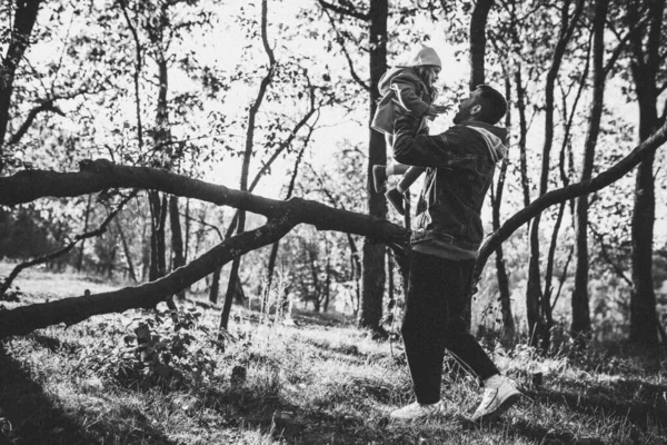 Счастливый отец и маленькая милая дочь, идущие по лесной тропинке осенью солнечный день — стоковое фото