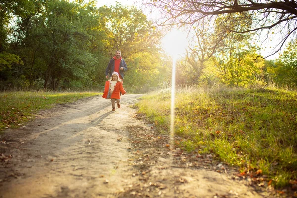 Ευτυχισμένος πατέρας και μικρή χαριτωμένη κόρη περπάτημα κάτω από το μονοπάτι του δάσους το φθινόπωρο ηλιόλουστη μέρα — Φωτογραφία Αρχείου