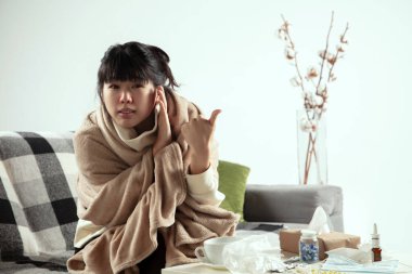 Ekoseye sarılmış bir kadın hasta, hasta, hapşıran ve öksüren bir kadın gibi görünüyor.