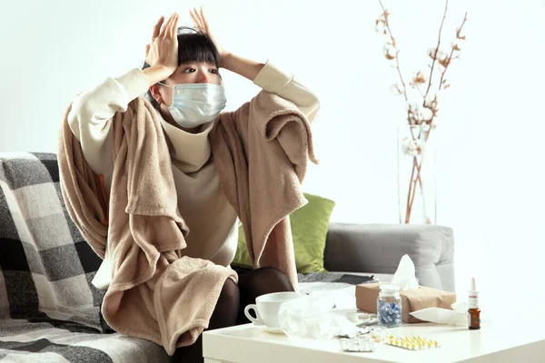 Kvinna insvept i en rutig och bär ansiktsmask försöker skydda sig från någons sjuka i närheten — Stockfoto