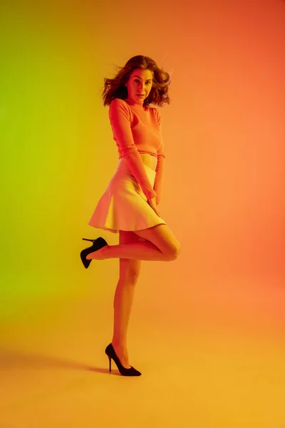 Menina sedutora bonita na moda, roupa romântica em gradiente brilhante verde-laranja fundo em luz de néon — Fotografia de Stock
