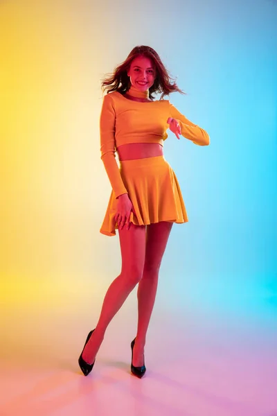 Hermosa chica seductora en traje de moda, romántico amarillo sobre brillante degradado amarillo-azul fondo en luz de neón — Foto de Stock