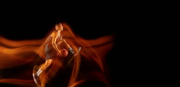 Mladý východoasijský basketbalista v akci a skok ve smíšeném světle přes tmavé pozadí studia. Koncepce sportu, pohybu, energie a dynamického, zdravého životního stylu. — Stock fotografie