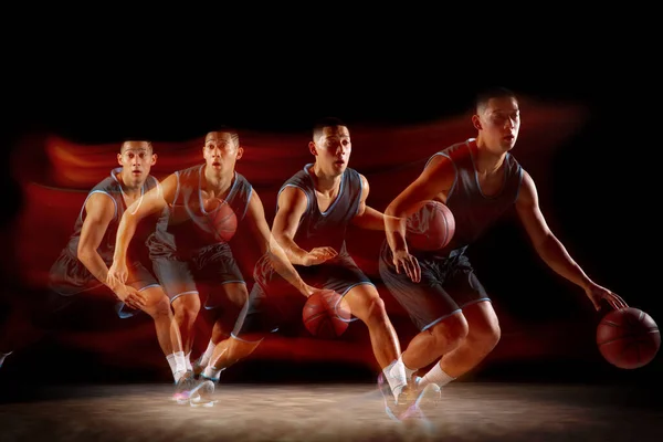 젊은 동양인 농구 선수가 움직이고 어두운 녹음실 배경 위에서 혼합 된 스트룹 조명 속으로 뛰어 든다. 스포츠, 운동, 에너지, 역동적 이고 건강 한 생활 방식에 대한 개념. — 스톡 사진