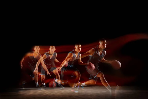 年轻的东亚篮球运动员在行动中，在黑暗的工作室背景上跳过混合的闪光灯。体育、运动、精力和充满活力、健康的生活方式的概念. — 图库照片