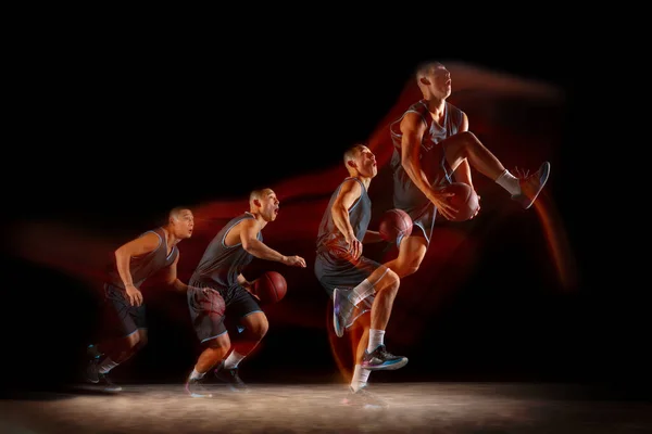 Jonge Oost-Aziatische basketbalspeler in actie en spring in gemengde stroboscoop licht over donkere studio achtergrond. Begrip sport, beweging, energie en dynamische, gezonde levensstijl. — Stockfoto