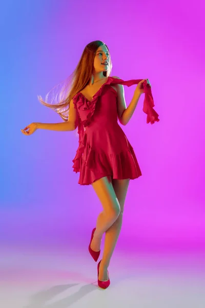 Menina feliz bonita na moda, roupa romântica em gradiente brilhante fundo roxo-azul em luz de néon — Fotografia de Stock