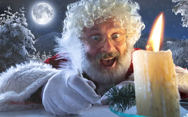 Gros plan portrait du Père Noël émotionnel écrivant une lettre, une liste de souhaits avec Nouvel An et Noël à minuit avec bougie — Photo