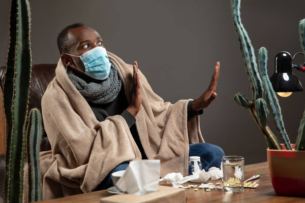 Man wrapped in a plaid wearing face mask trying to protect from somebodys sick