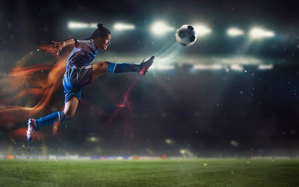 Jovem jogador de futebol ou futebol chutando bola no salto no estádio movimento, ação, conceito de atividade. Folheto para anúncio, projeto. — Fotografia de Stock