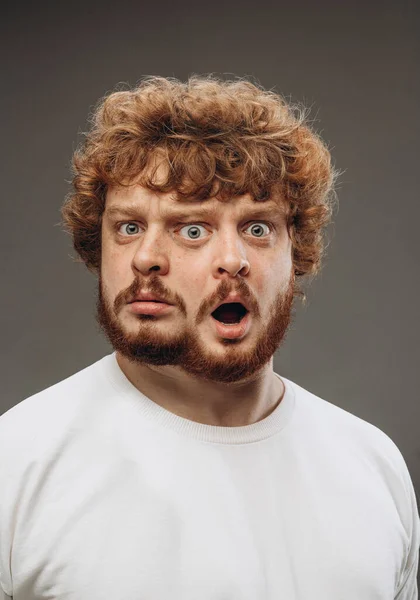 Jonge man met dubbele emoties combinatie op gezicht geïsoleerd op donkere achtergrond, emotioneel en expressief — Stockfoto