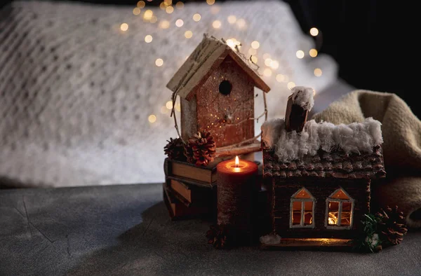 Miniaturas de casas aisladas sobre fondo gris y blanco con luces de guirnalda. El concepto de ambiente hogareño y confort. — Foto de Stock